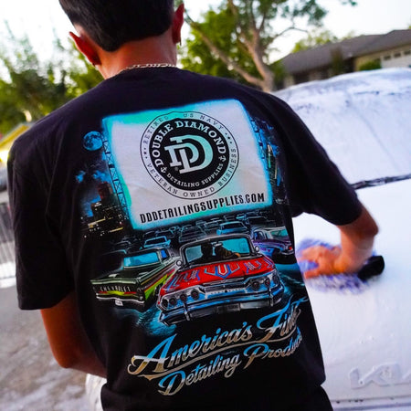 Close-up of the Drive In Tee back print: lowriders at a drive-in with the Double Diamond logo on screen